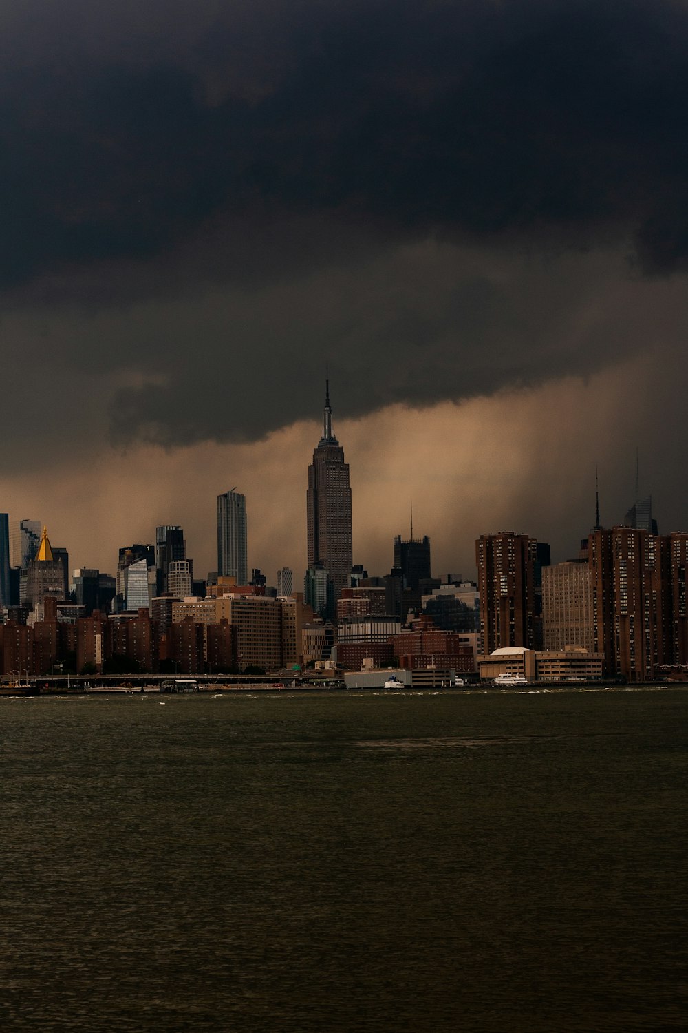 a large city with a very tall building under a cloudy sky