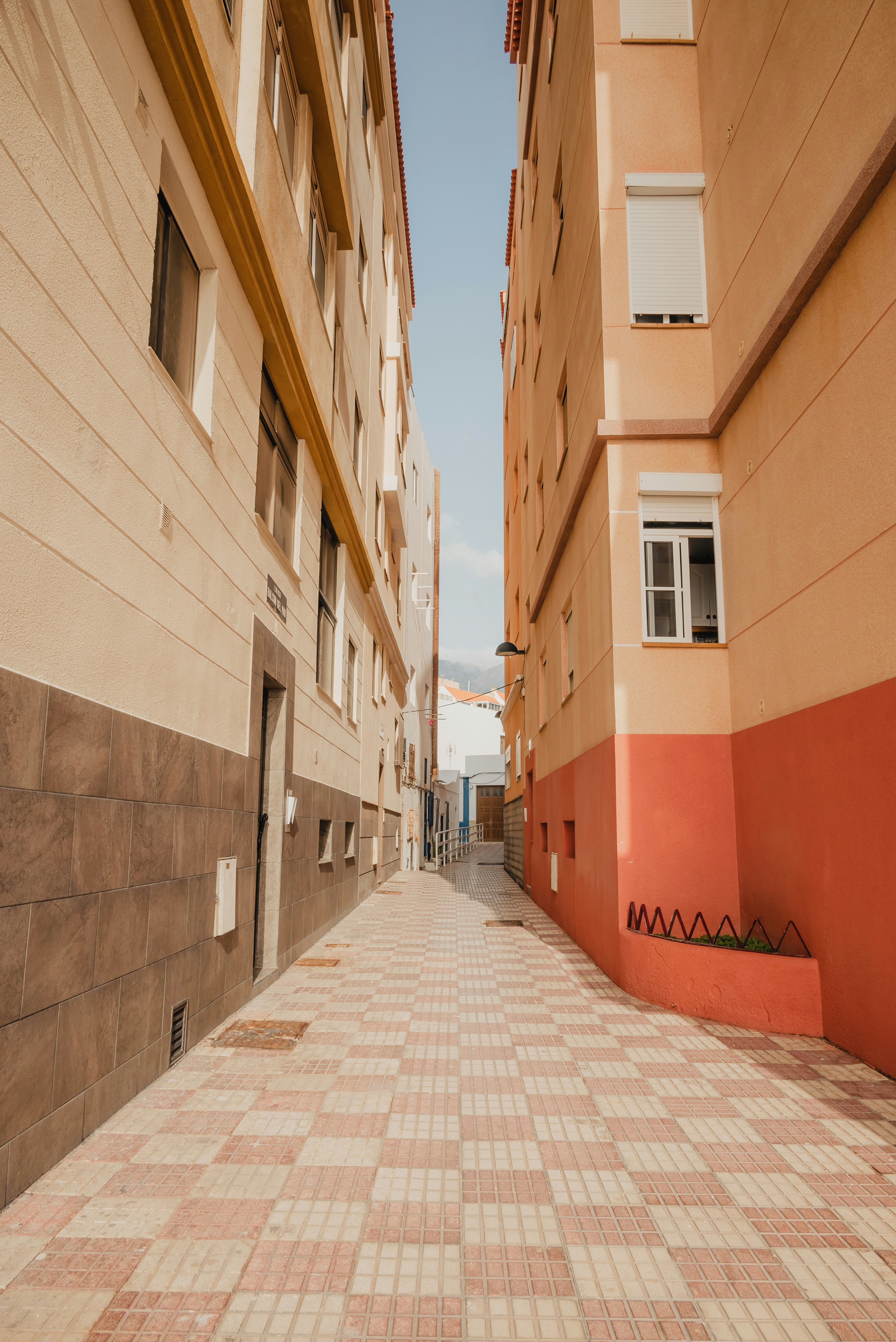 a brick sidewalk between two buildings in a city