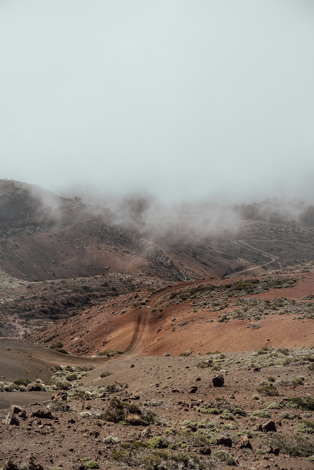 a dirt field with a hill in the background