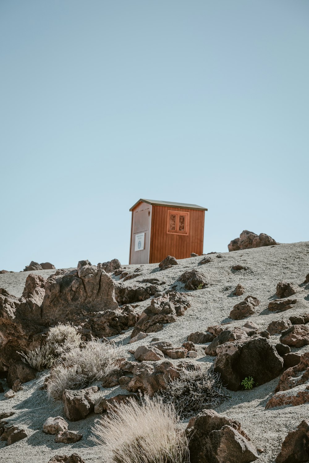 a small outhouse on a rocky hillside