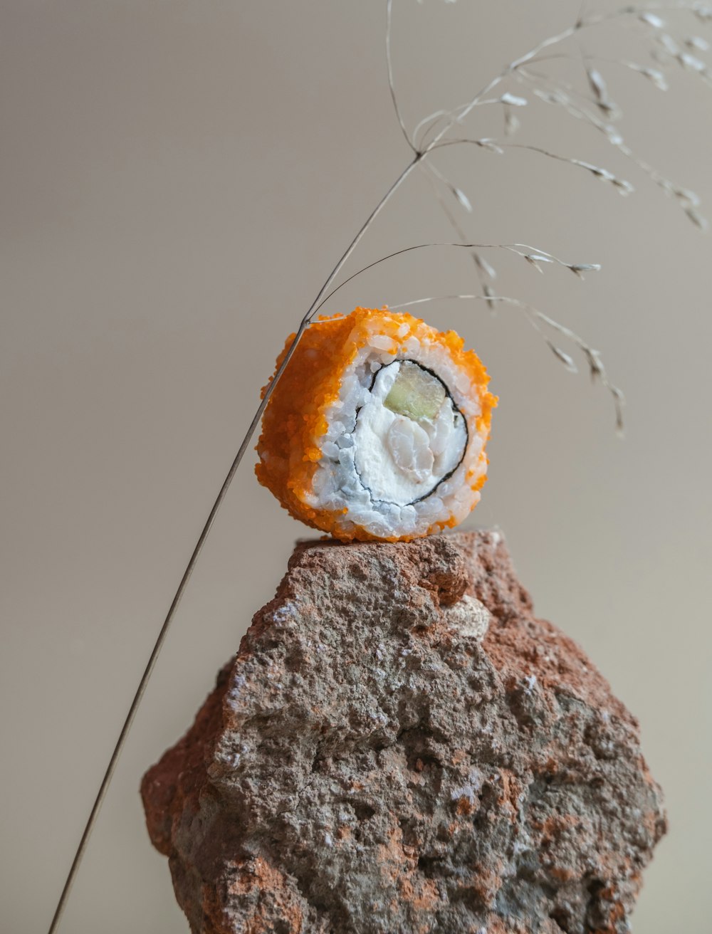 a piece of sushi sitting on top of a rock