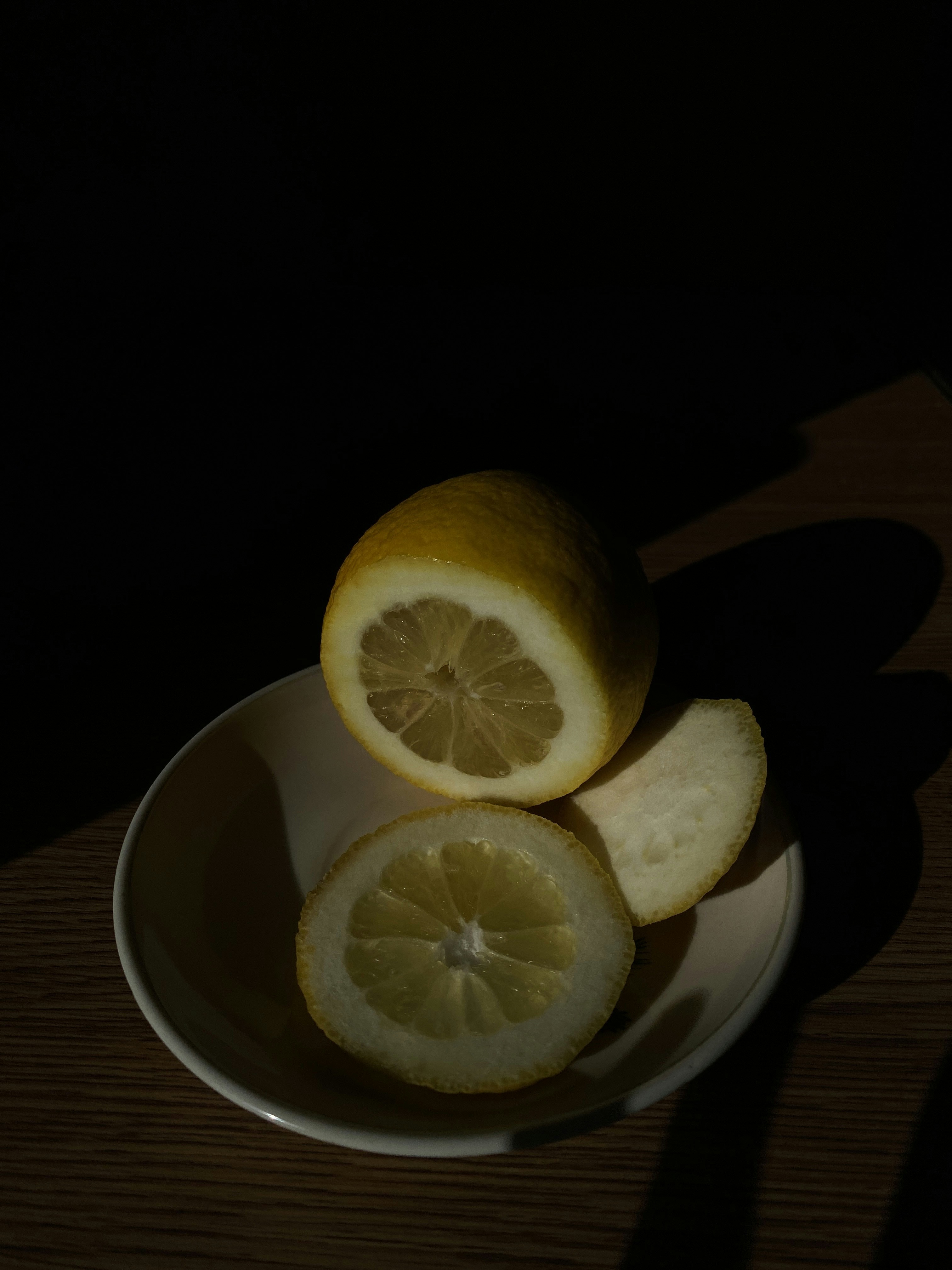 Lemon Maggi with lemon slices and herbs in dark bowl, atmospheric food shot