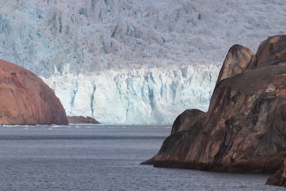 a group of large rocks sitting next to a body of water