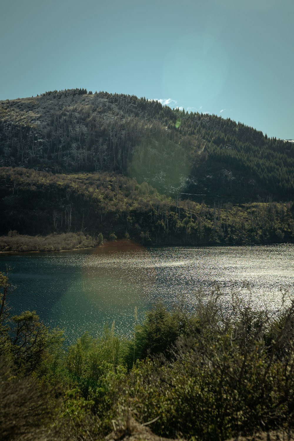 a large body of water surrounded by a lush green hillside