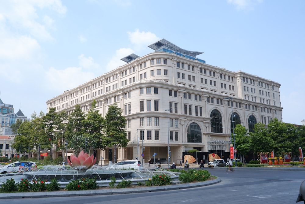 Un gran edificio blanco con una fuente frente a él