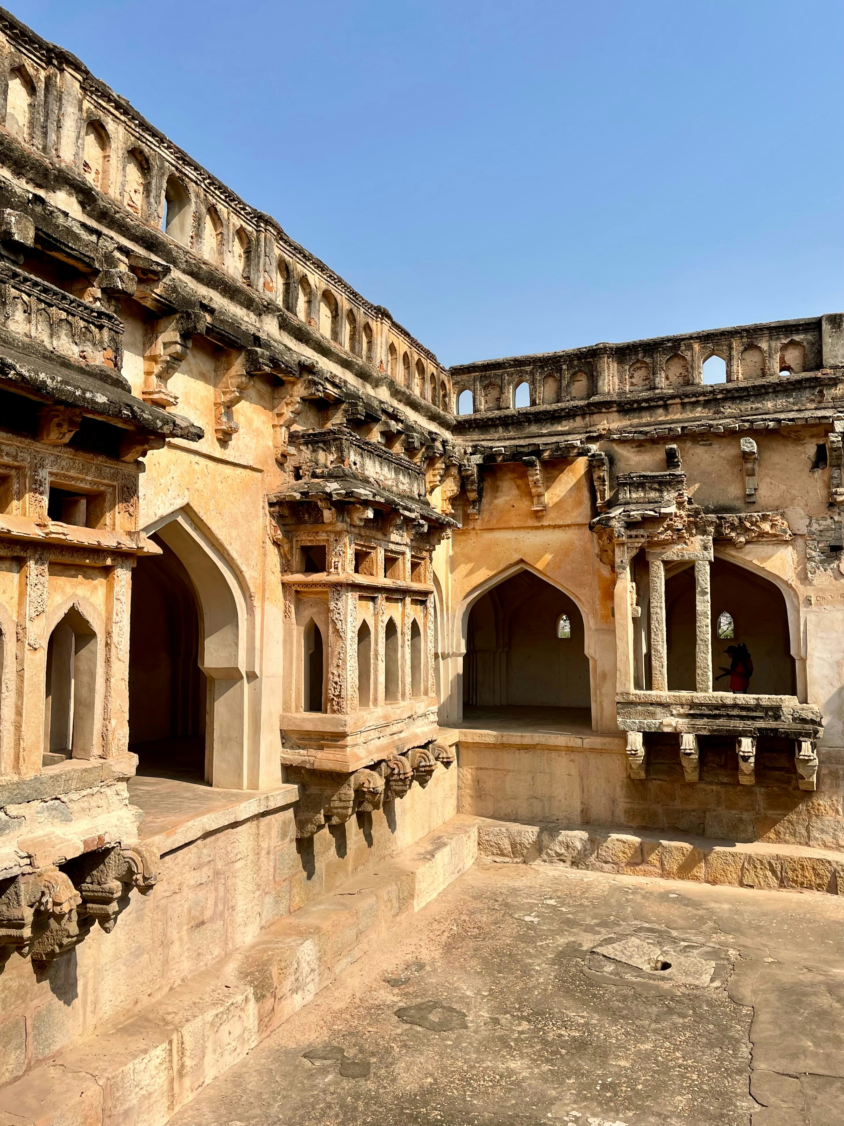 Historic Indian architecture monument with intricate stonework under blue sky