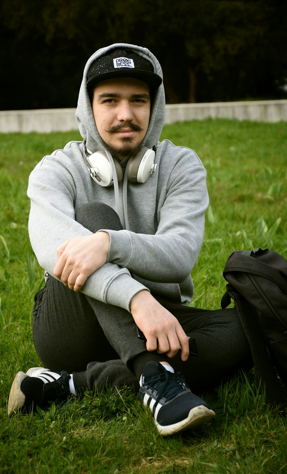 a man sitting in the grass wearing headphones