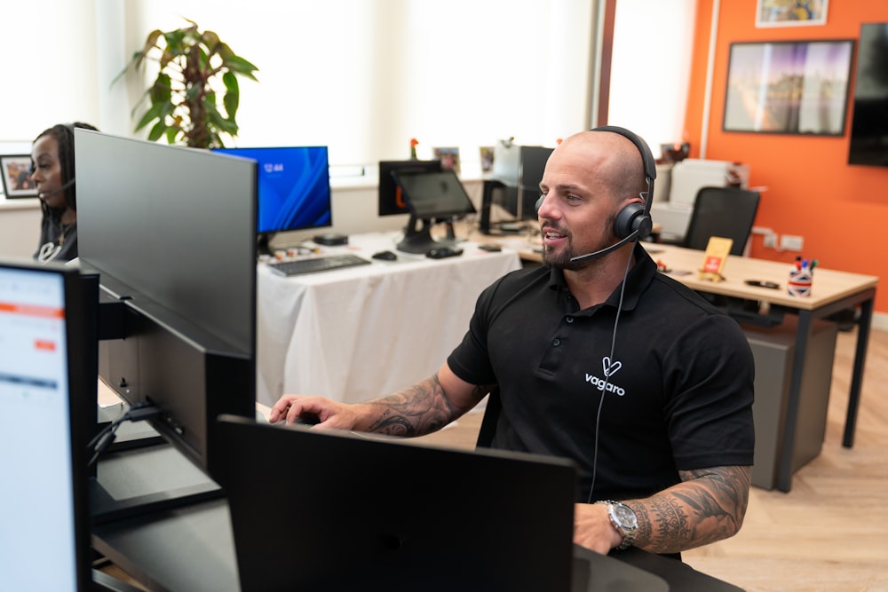 Un hombre con auriculares sentado frente a una computadora