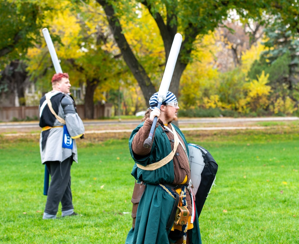 a man in a costume holding two baseball bats