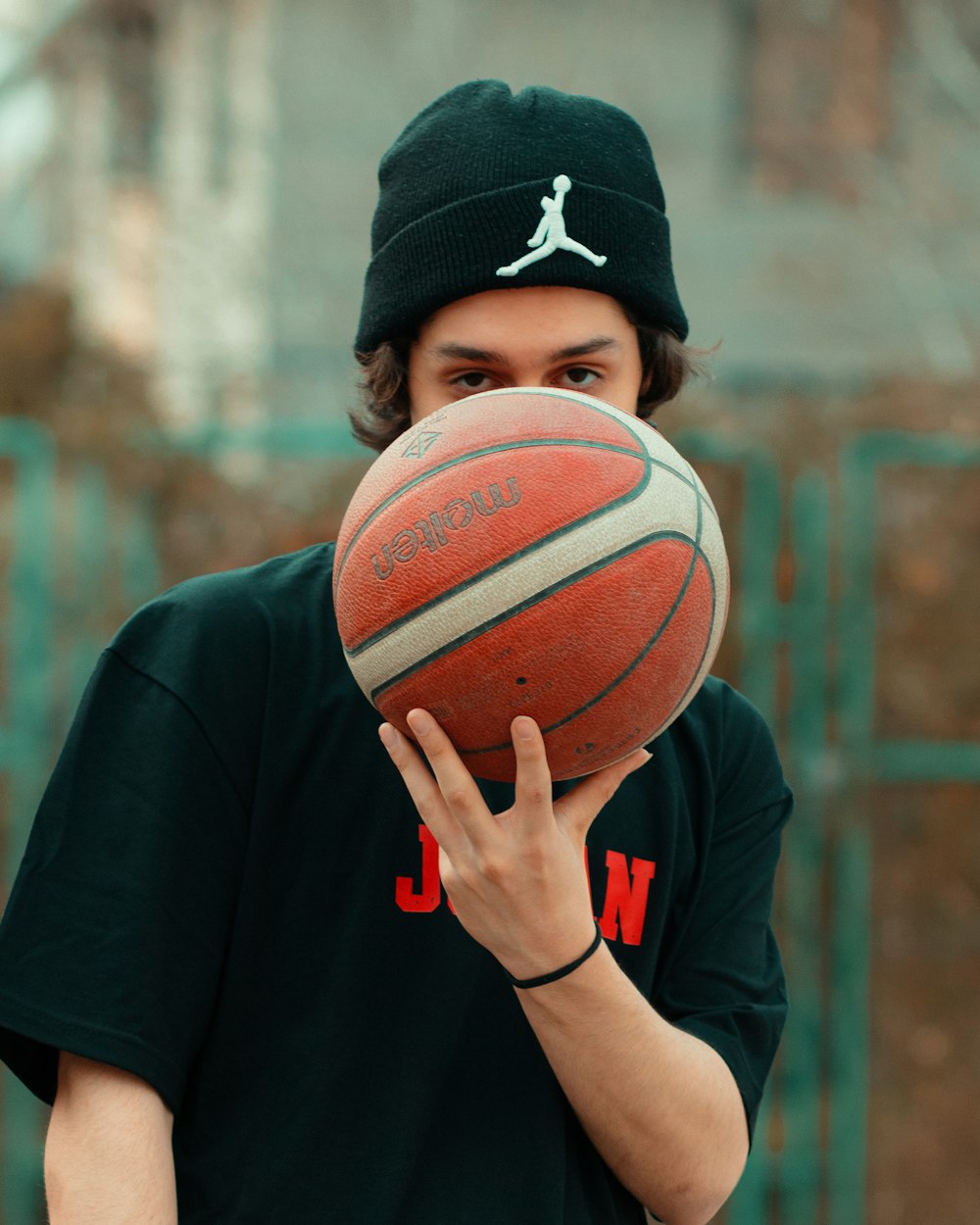 a man holding a basketball up to his face