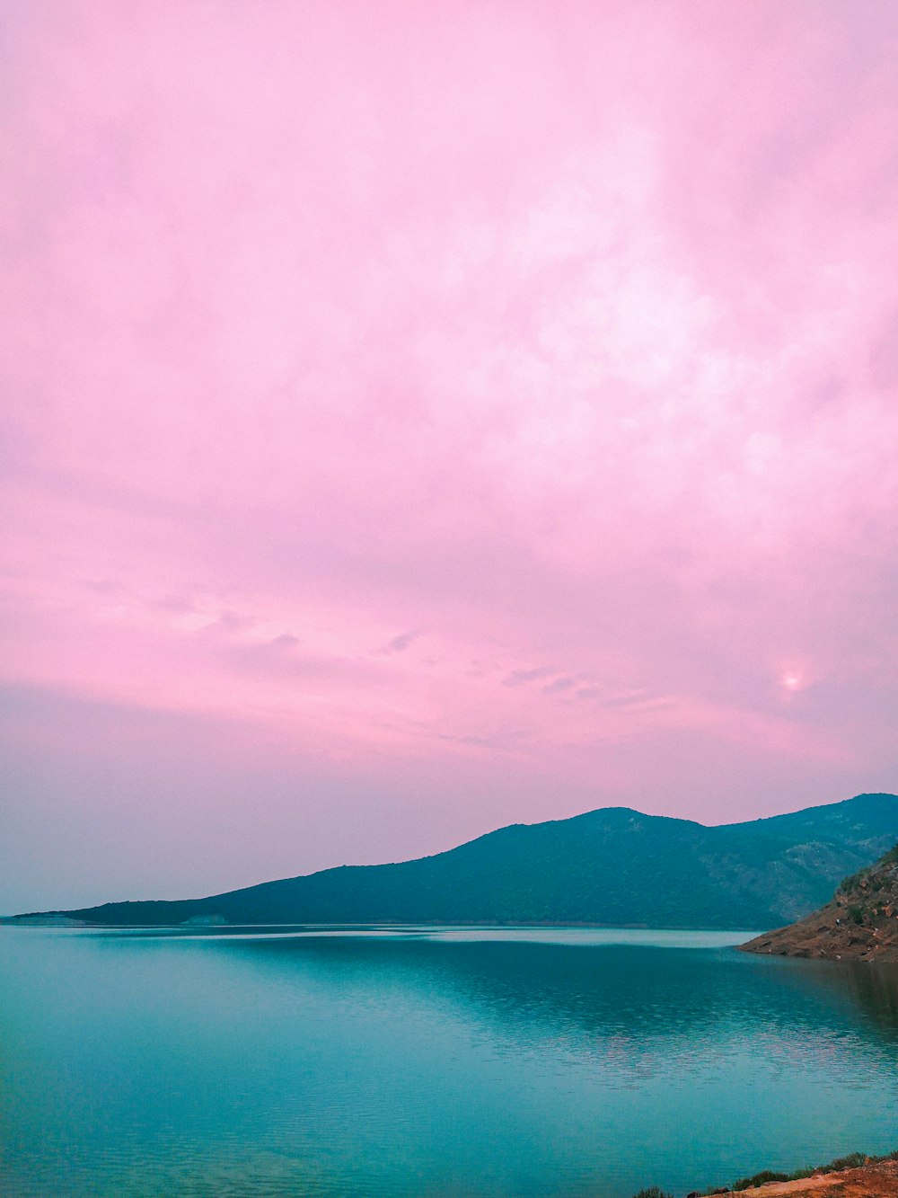 a large body of water sitting under a cloudy sky