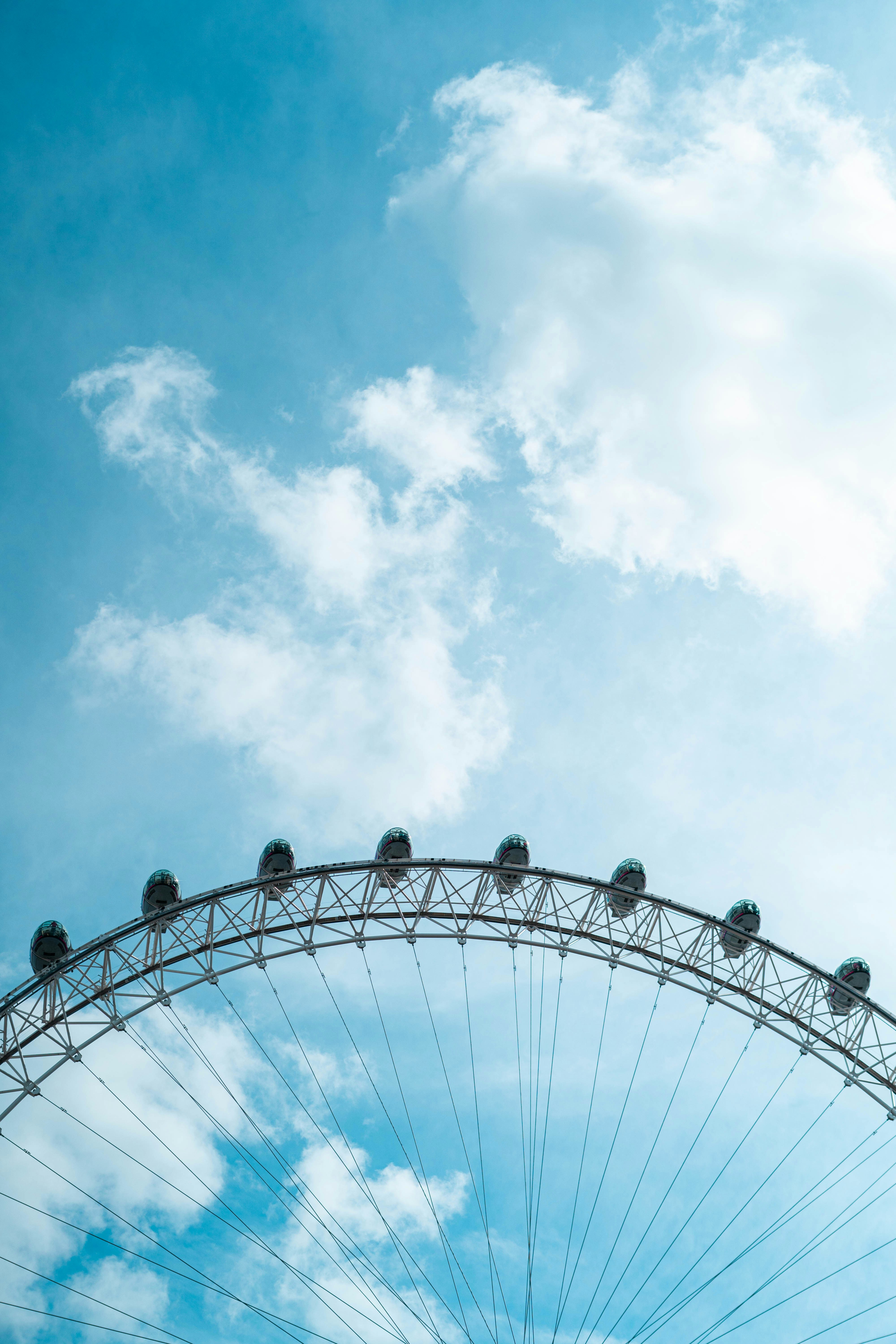 a large ferris wheel sitting under a cloudy blue sky
