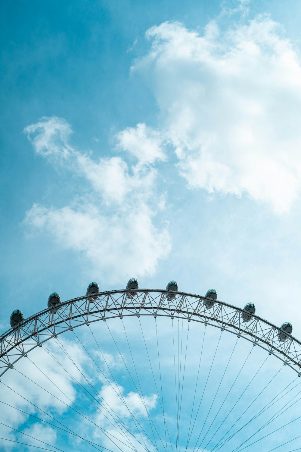 a large ferris wheel sitting under a cloudy blue sky