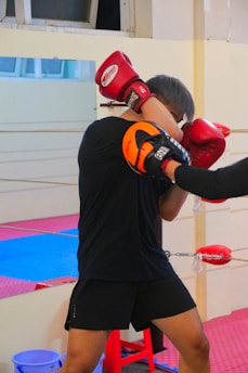 a man wearing red boxing gloves and a black shirt