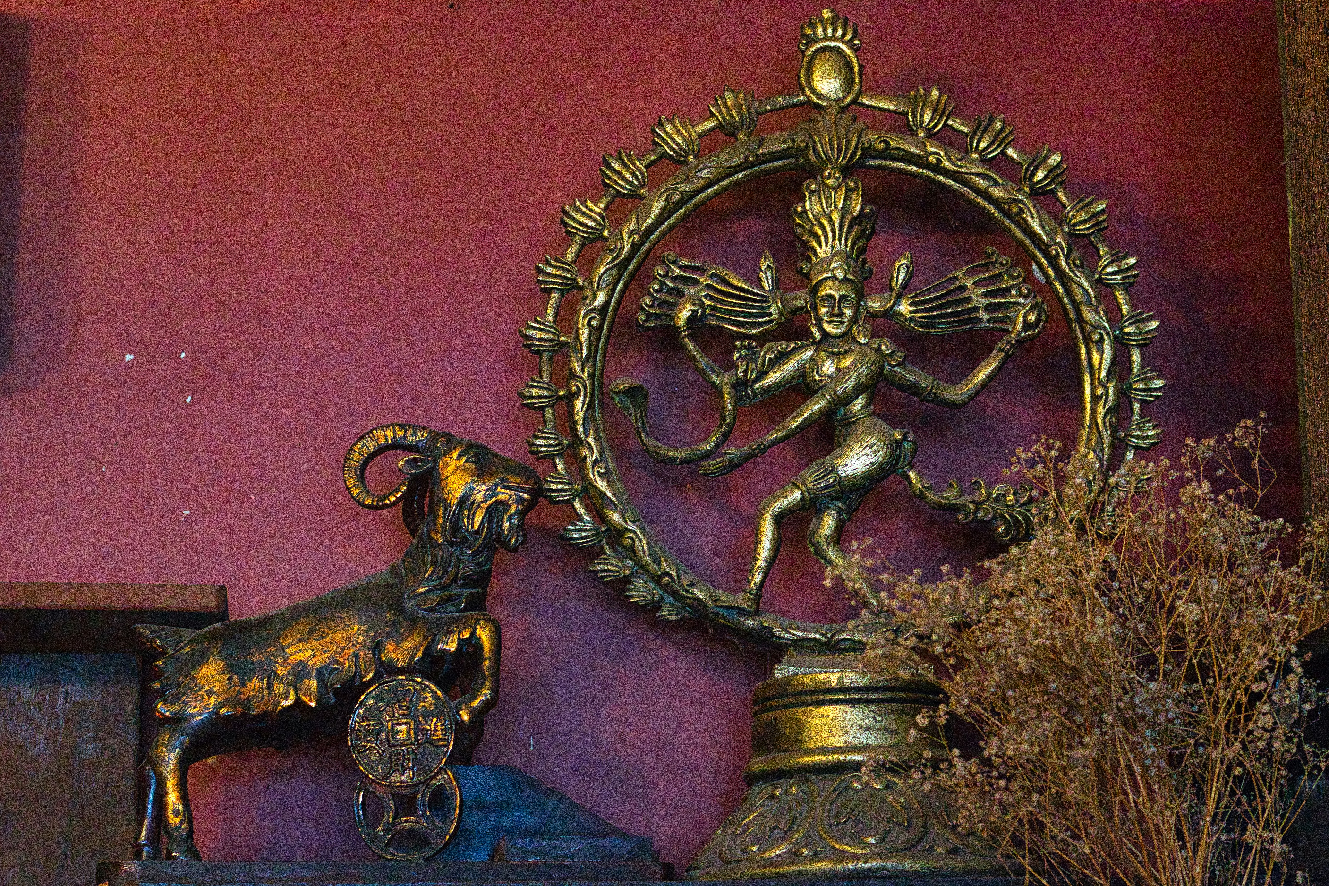 a statue of a ram and a clock on a shelf