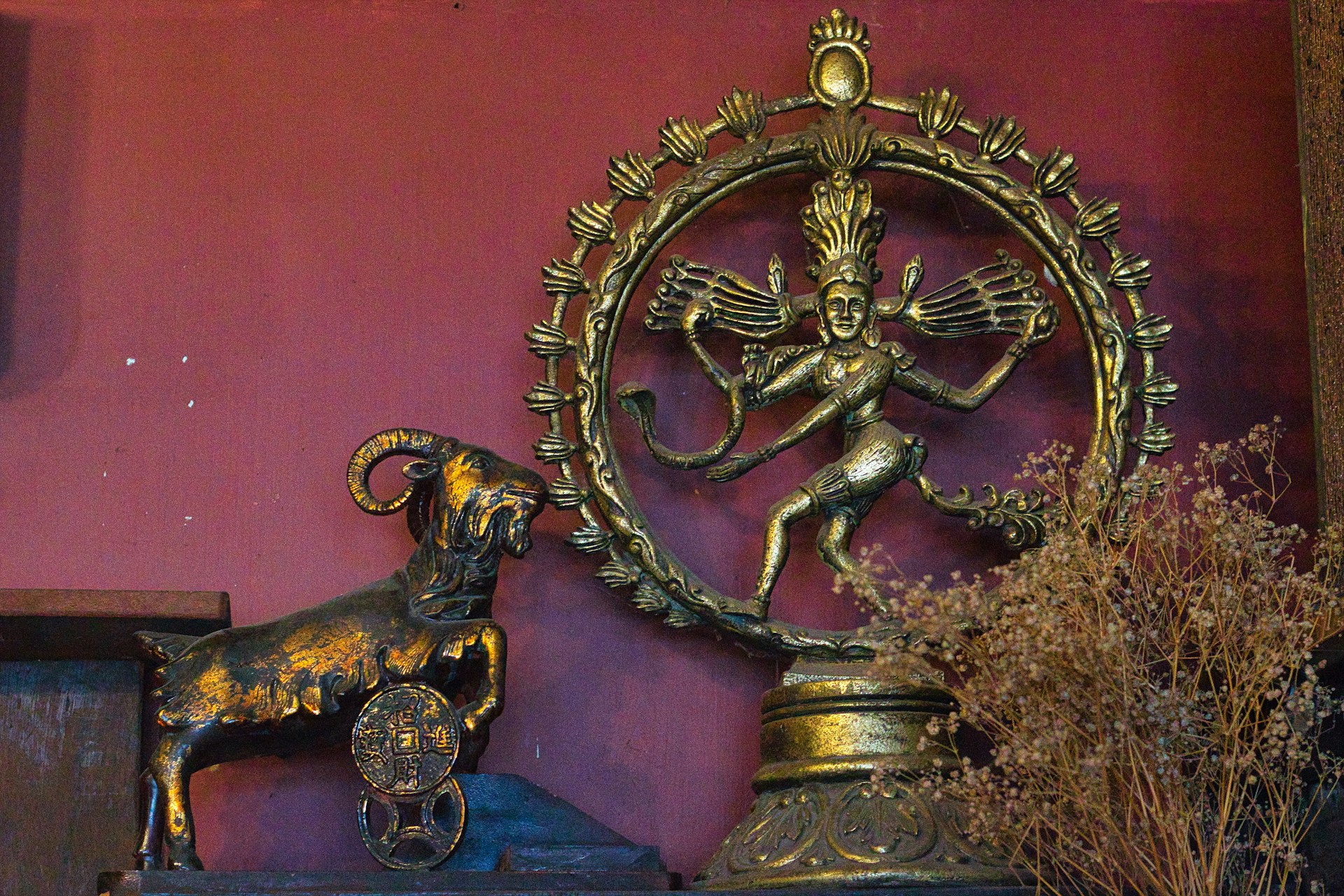 a statue of a ram and a clock on a shelf