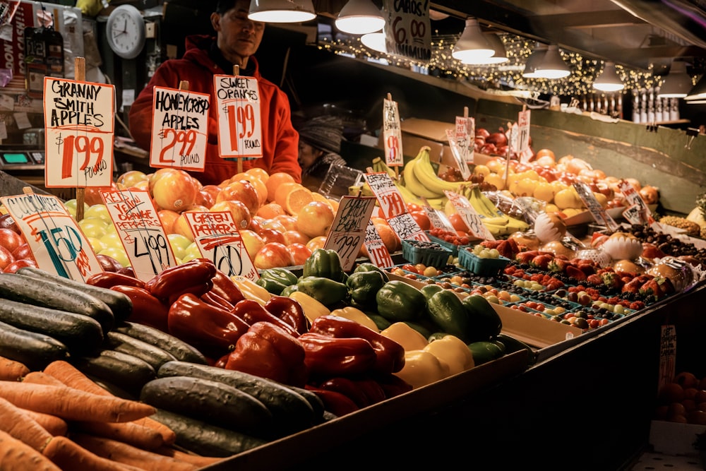 a man standing in front of a display of fruits and vegetables