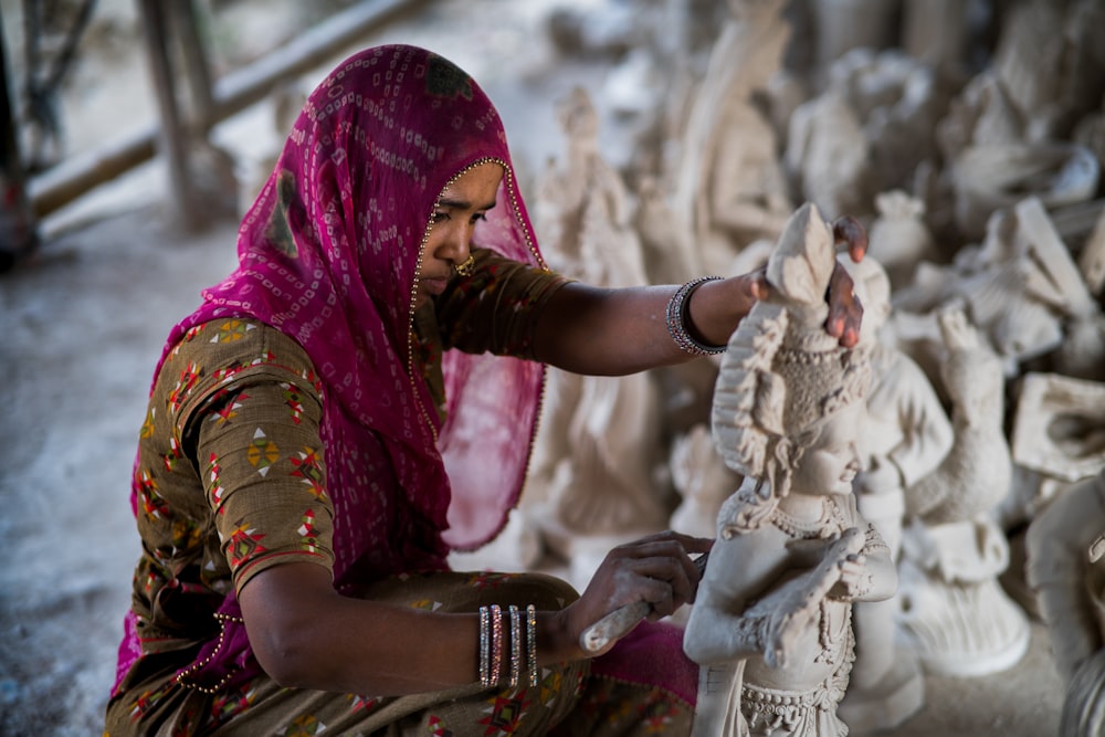 a woman is working on a statue
