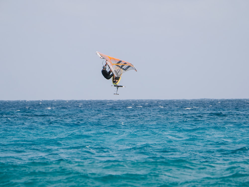 a person on a surfboard in the air over the ocean