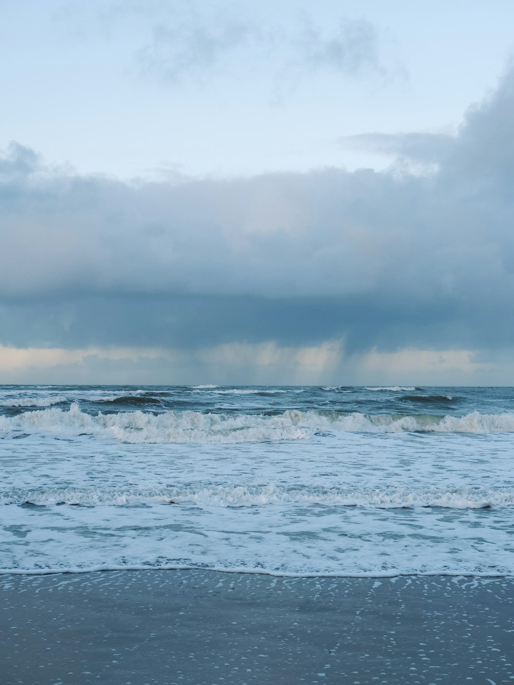 a person walking on a beach with a surfboard