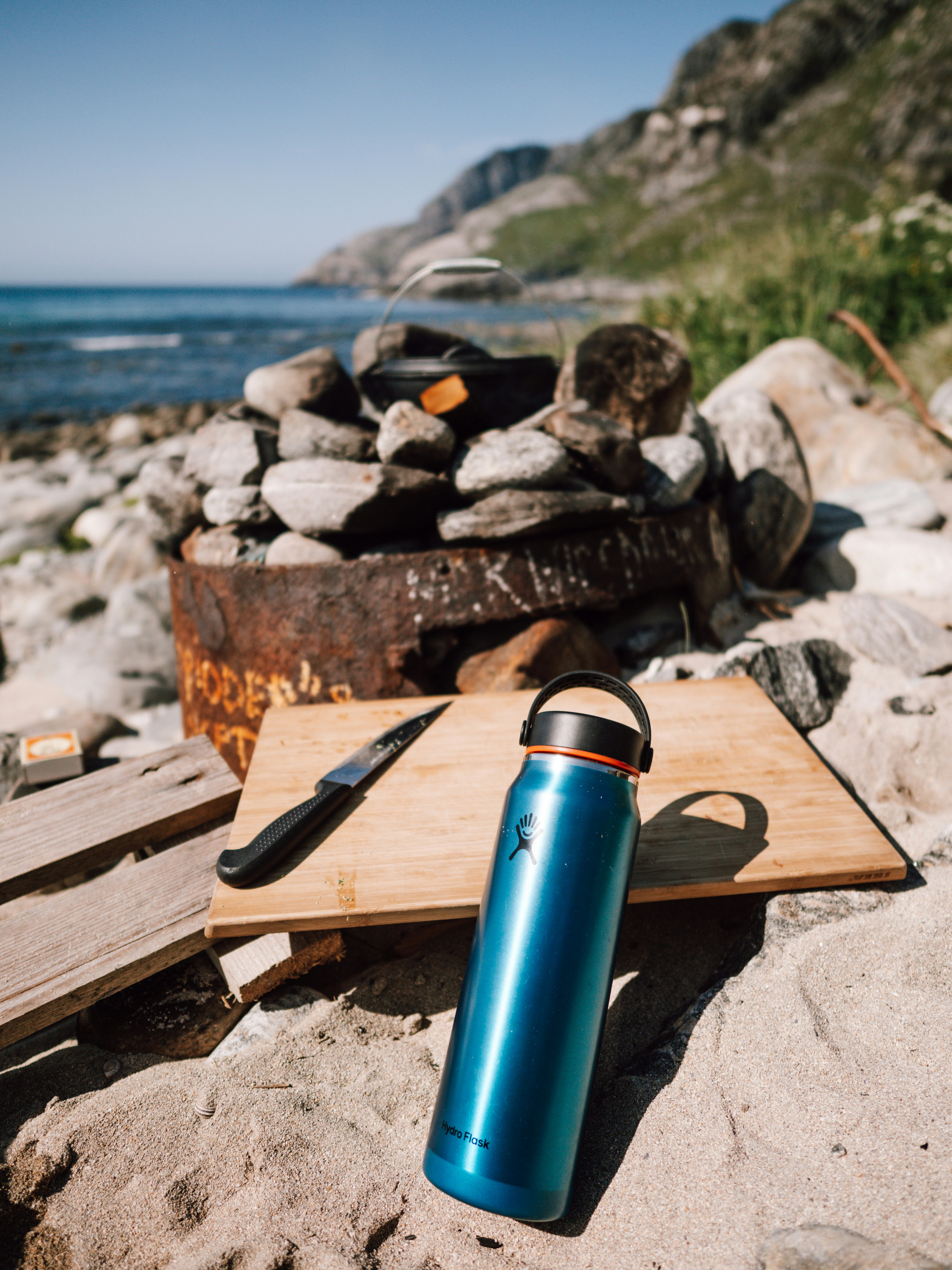 a blue water bottle sitting on top of a wooden cutting board