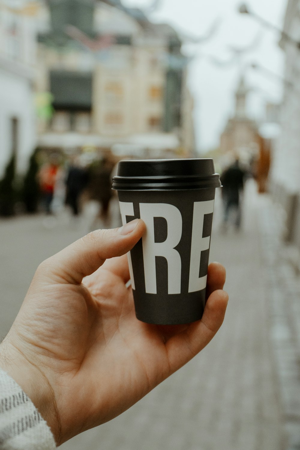 a hand holding a coffee cup with the word free on it