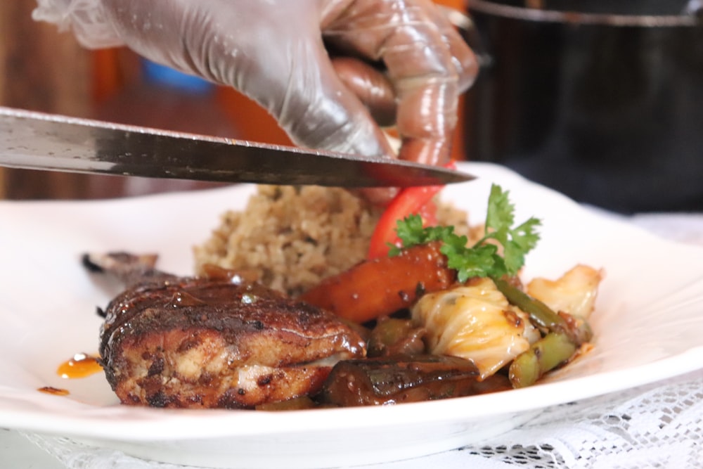 a person cutting a piece of meat with a knife