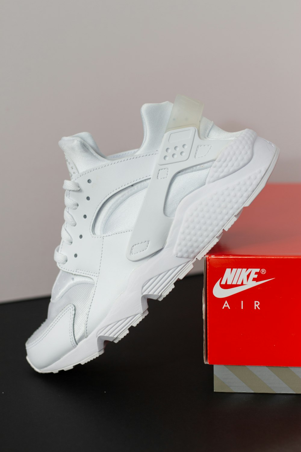 a pair of white nike shoes next to a box