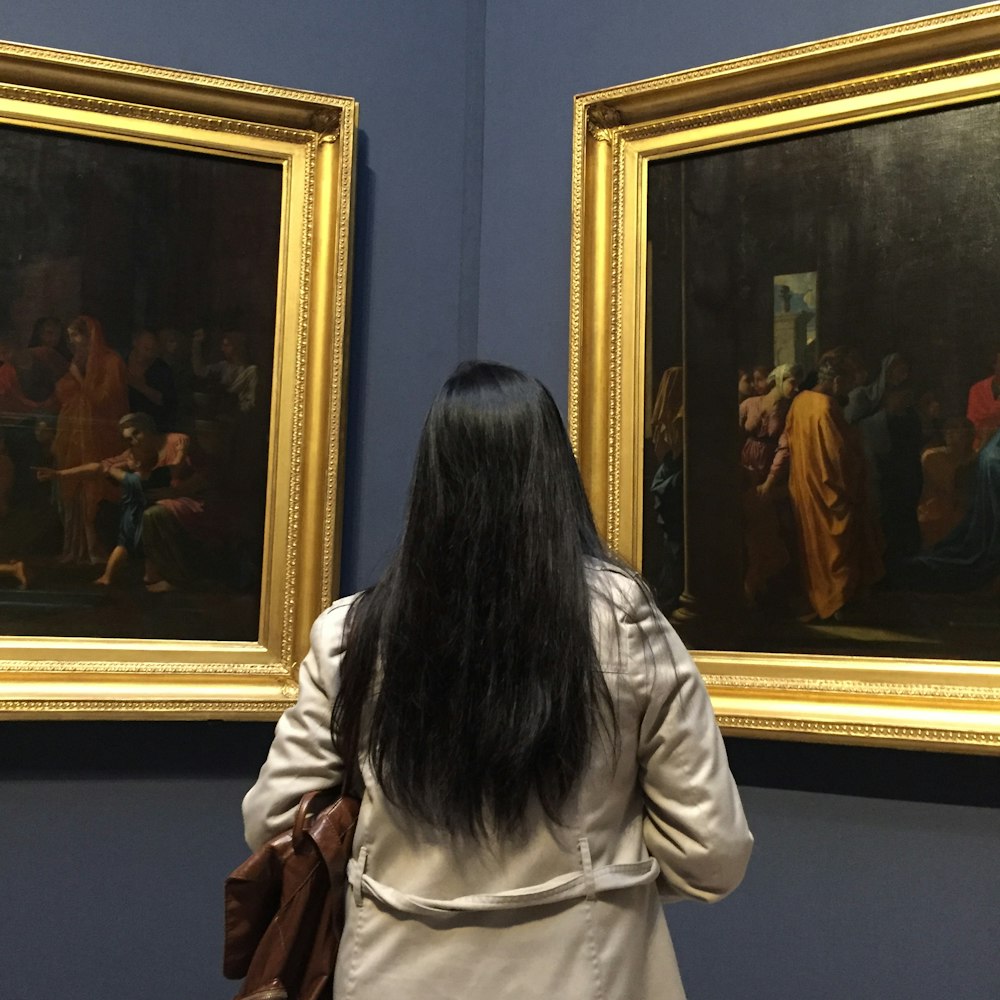 a woman standing in front of two paintings