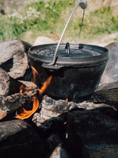 a pot on fire with tongs sticking out of it