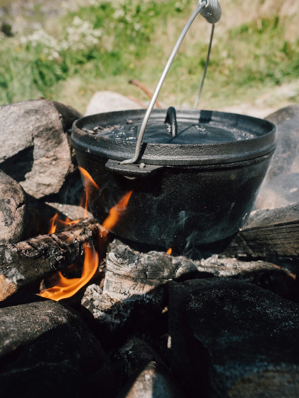 a pot on fire with tongs sticking out of it