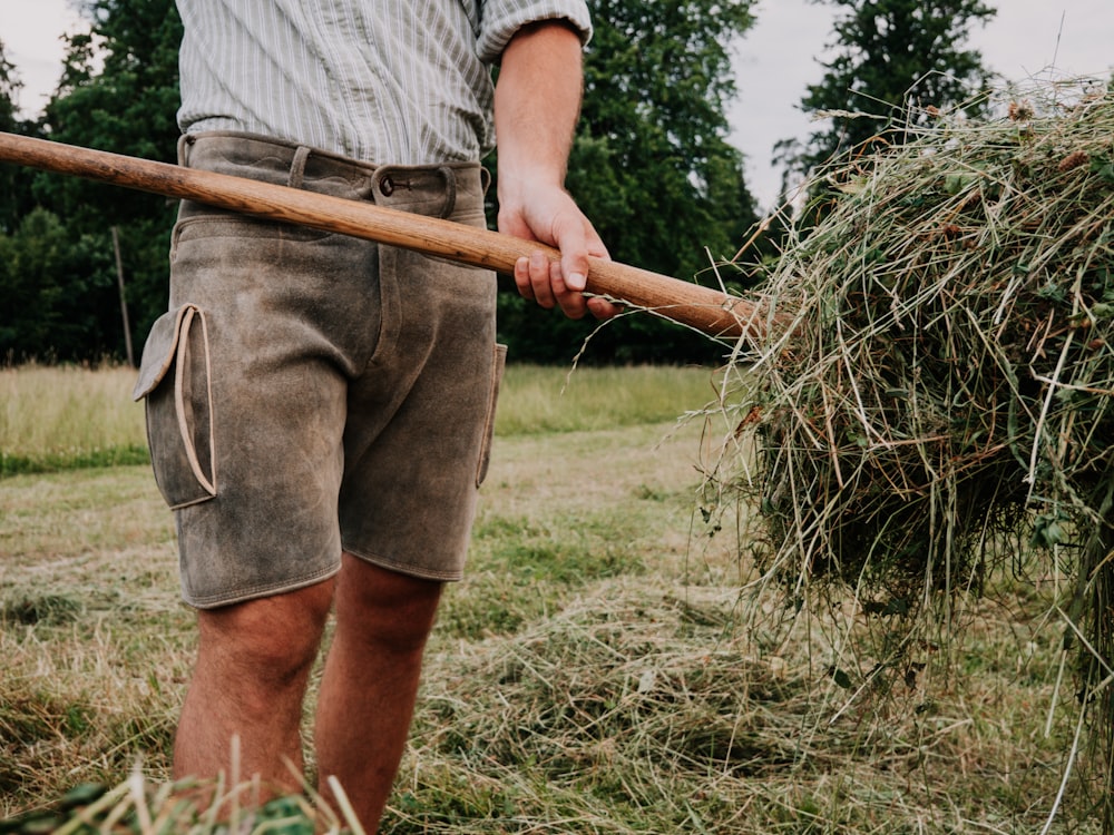 a man holding a stick in a field