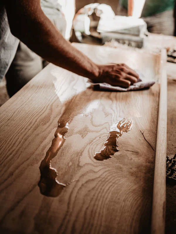 A person polishing a wooden table
