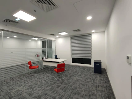 an empty office with a desk and chairs