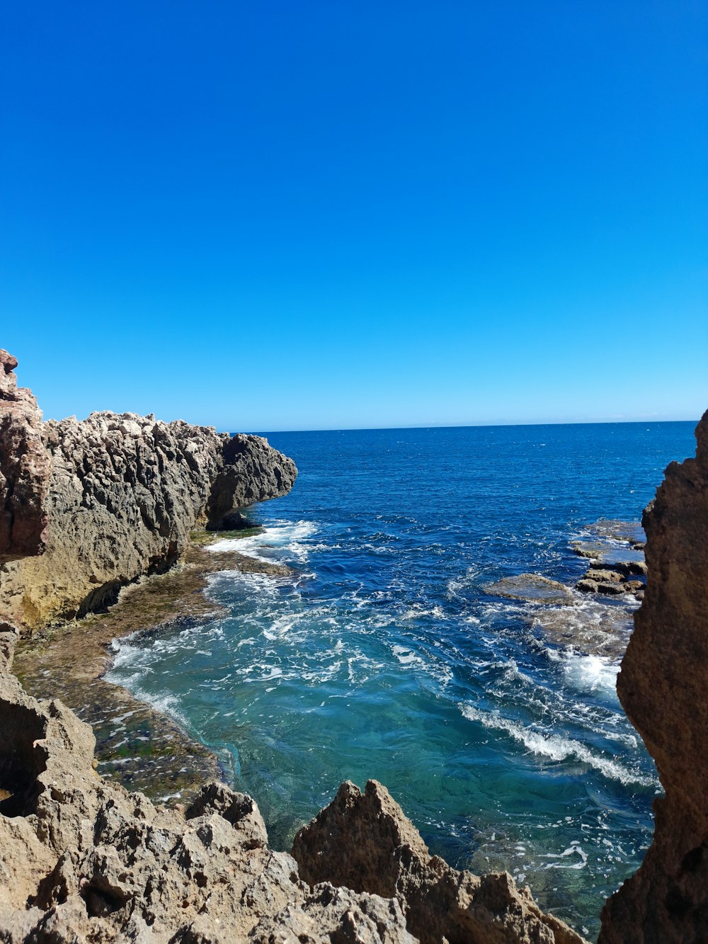 a view of the ocean from a rocky cliff