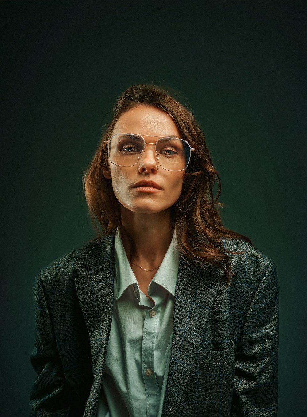 a woman wearing glasses and a suit