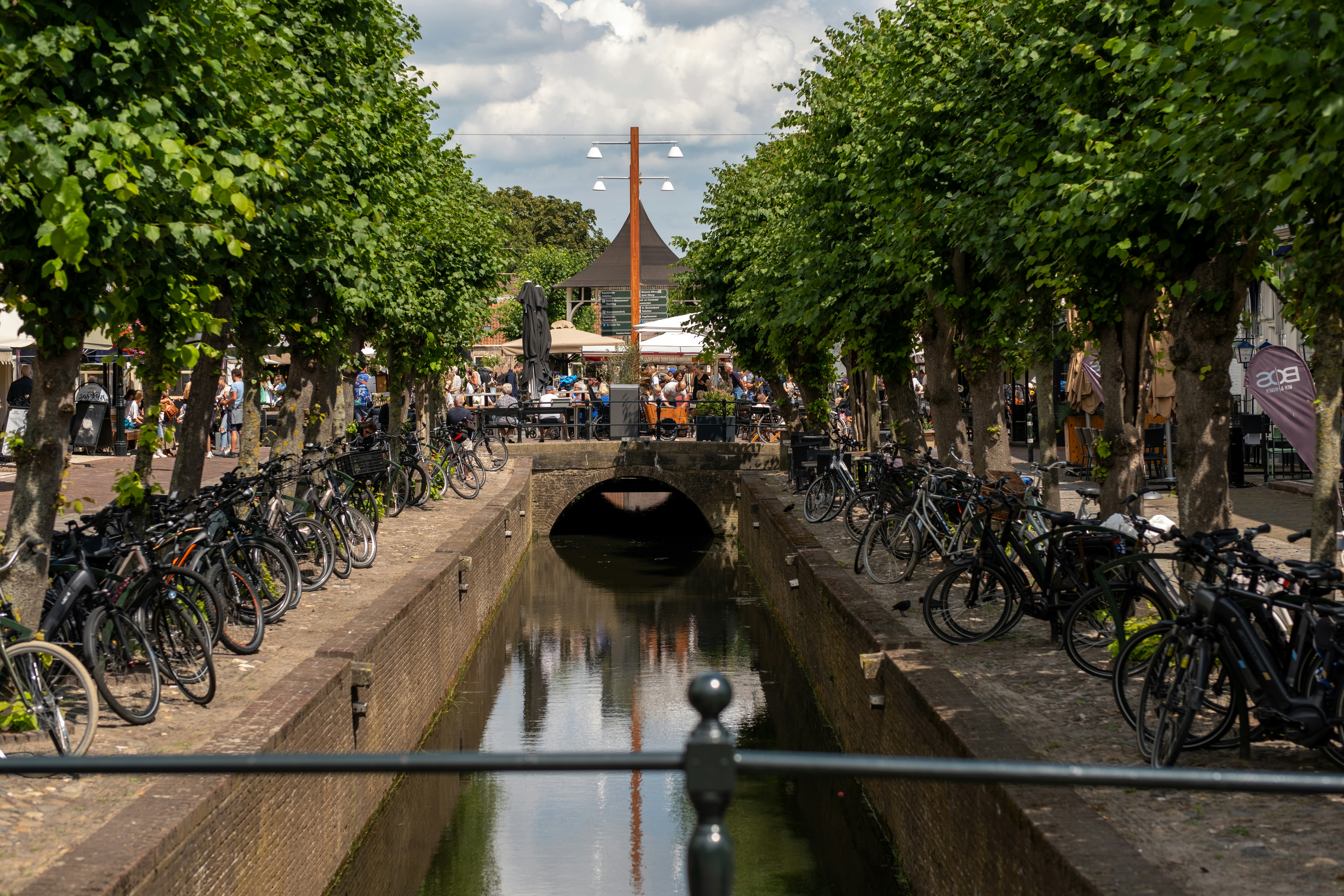 a bunch of bikes are parked along a canal
