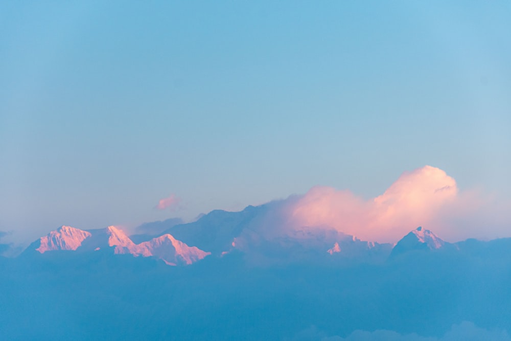 a view of a mountain range with clouds in the foreground