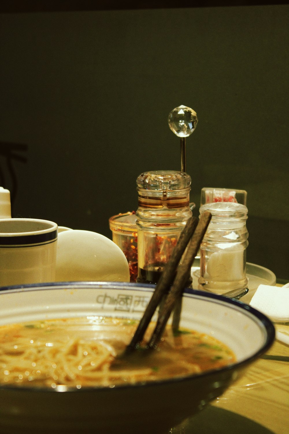 a bowl of soup with chopsticks on a table