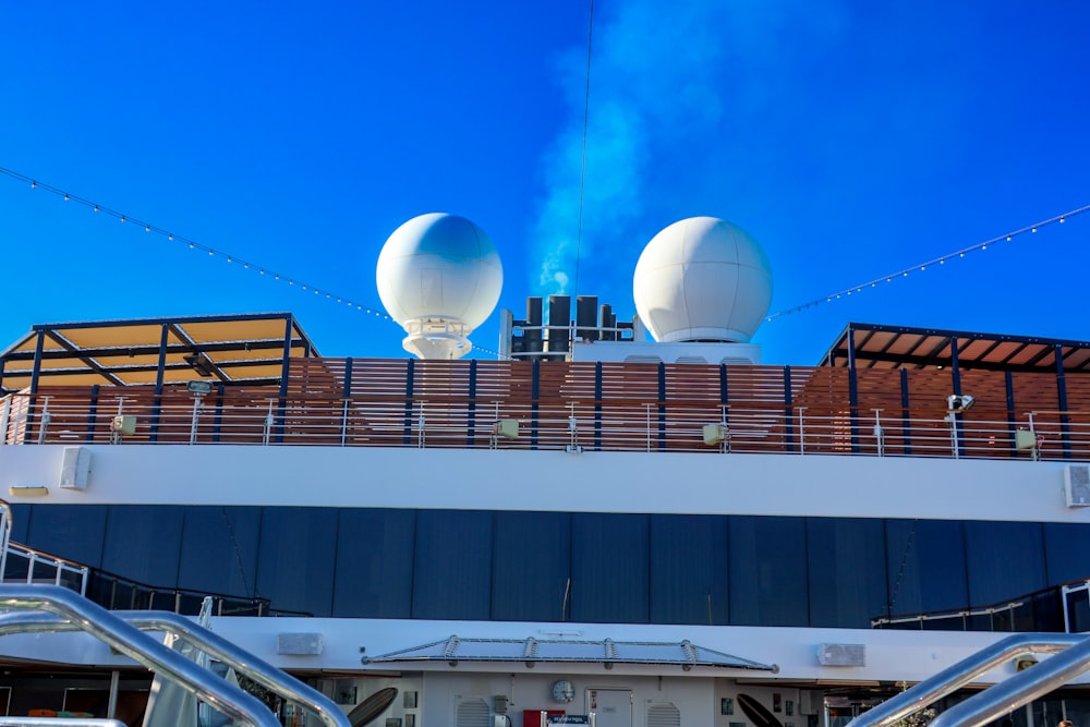a cruise ship with two large white balls on top of it