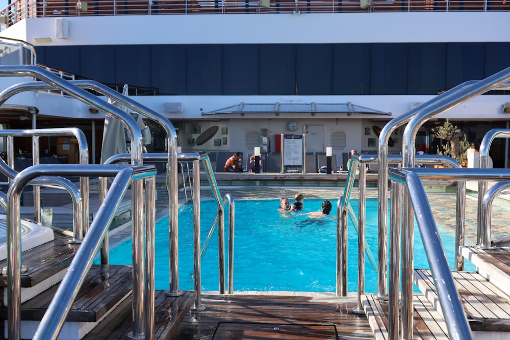 a group of people swimming in a pool on a cruise ship