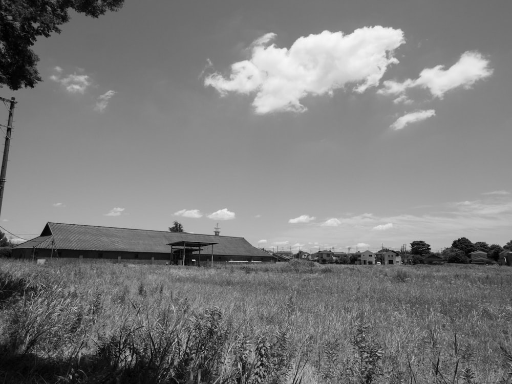 a black and white photo of a barn in a field