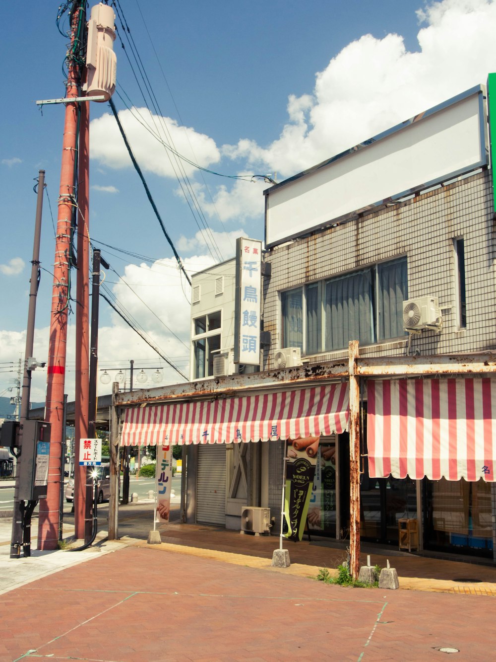 Un edificio con un toldo a rayas en una esquina de la calle