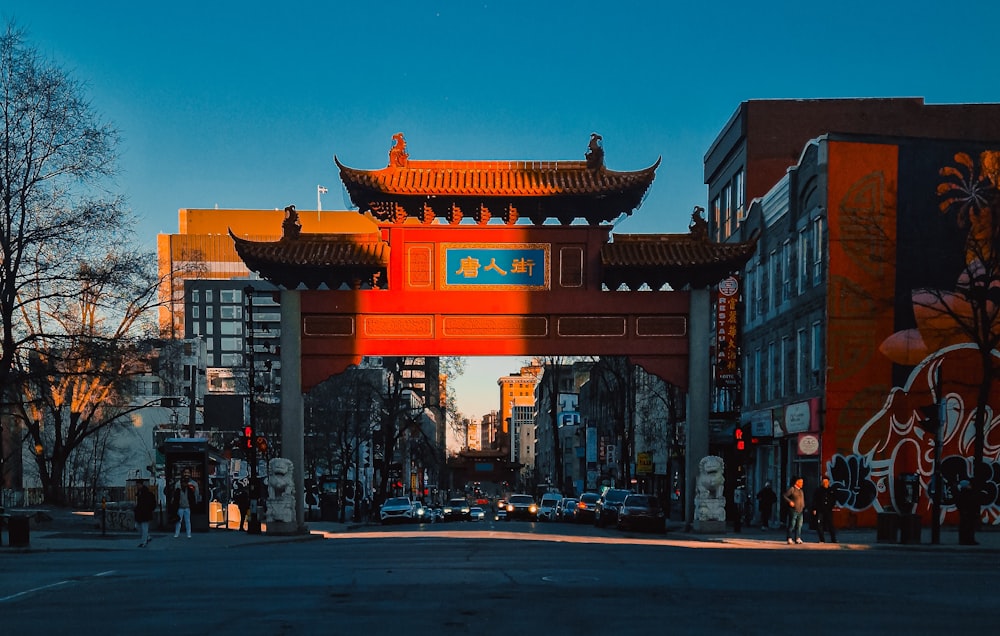 a red bridge over a city street with buildings in the background