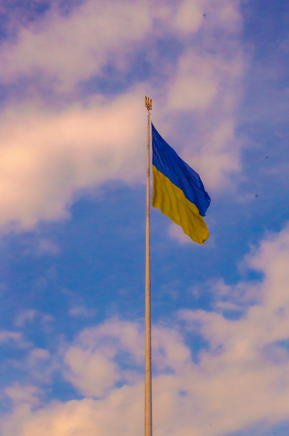 a blue and yellow flag flying in the sky