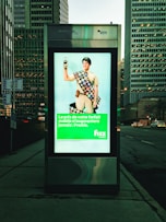 a bus stop with a poster of a man holding a cell phone