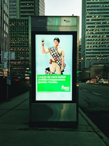 a bus stop with a poster of a man holding a cell phone