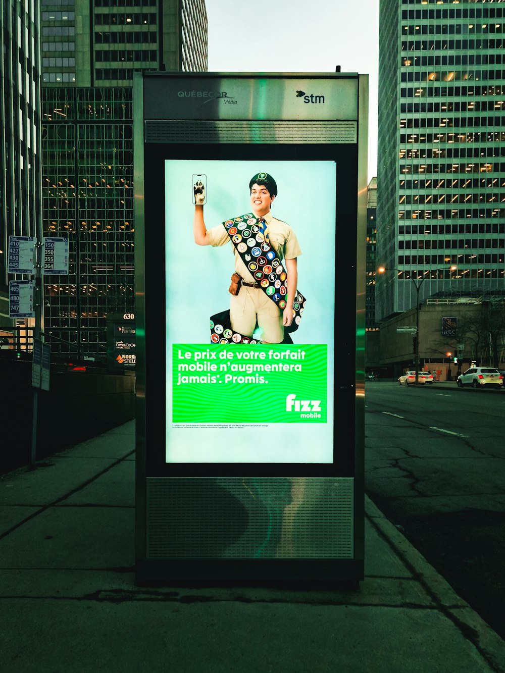 a bus stop with a poster of a man holding a cell phone