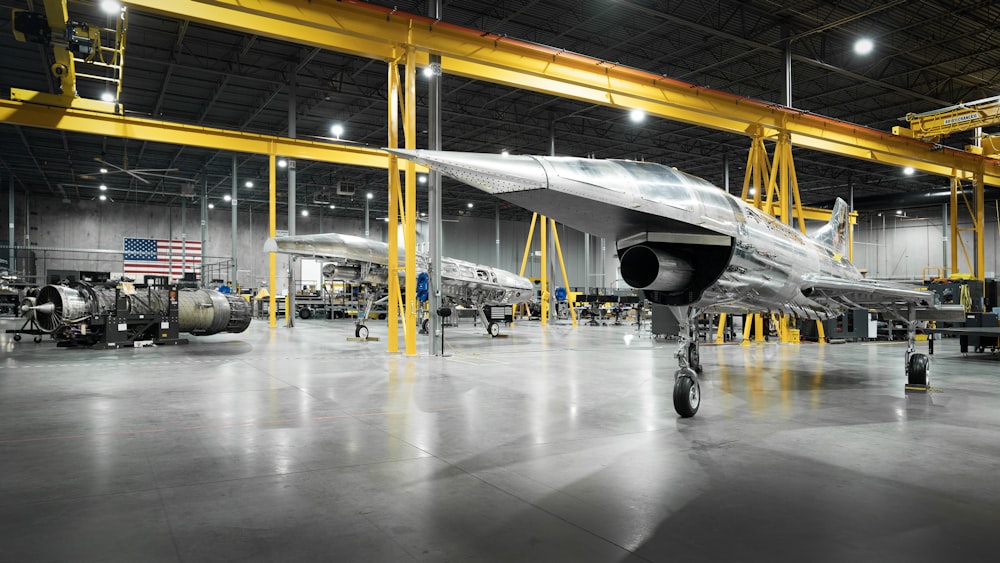 a jet sitting inside of a hangar next to other planes