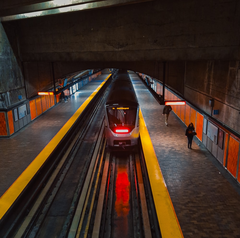 a train traveling through a train station under a bridge